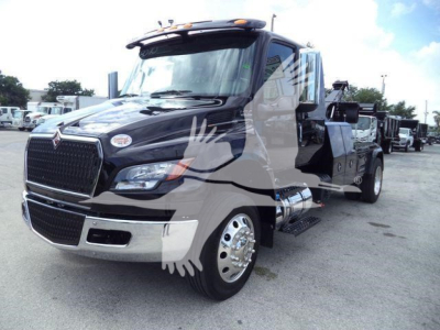 International MV truck with a glossy black cab and chrome grille, side steps, large mirrors, and a winch category tag visible in the background.