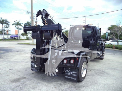 Tow truck with a front-mounted hydraulic winch and crane, International MV model, truck bed visible, stock number J78070, VIN 3HAEUMMLXSL178070 precision label not legible.
