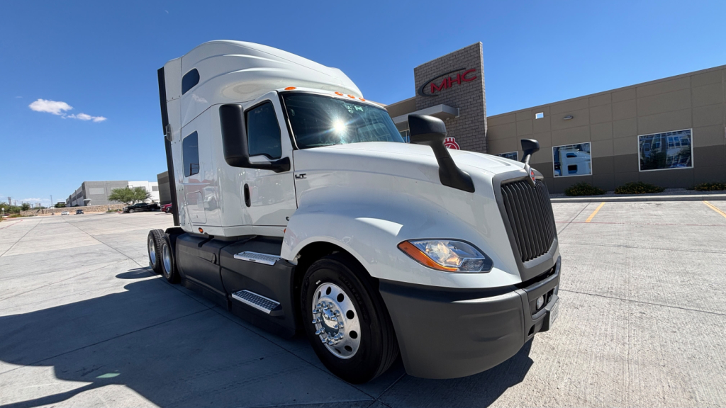 Truck cab exterior showing International LT625 with white paint and black grille, forward view in dealership lot.
