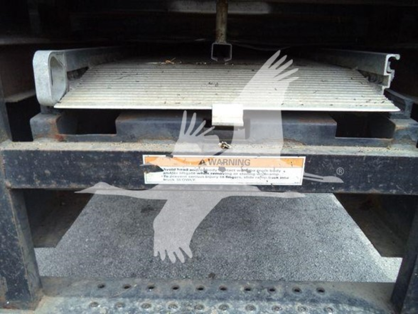 Hino 268a refrigerated truck component with metal platform and warning label visible