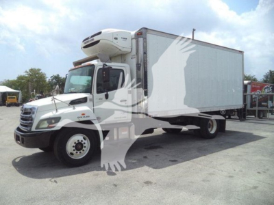2015 Hino 268a refrigerated box truck shown in side-angle view with hoist refrigeration unit on cab roof and white cargo area.