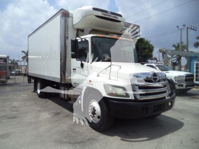 Hino 268a refrigerated truck with Thermo King reefer unit on cabover, white cargo box, side view showing front grille and dual rear axles.