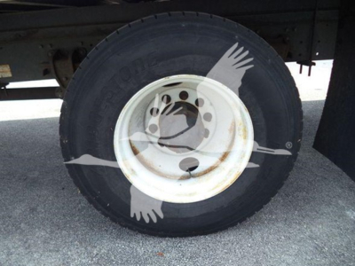 Truck wheel showing front tire and white steel rim with hub on a refrigerated 2015 Hino 268a listing.