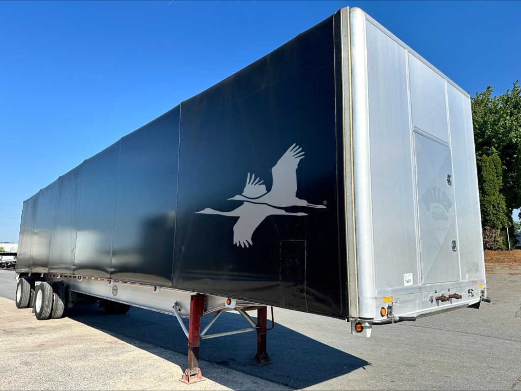 Curtainside trailer showing side and rear with Mac logo eagle design and front landing gear.