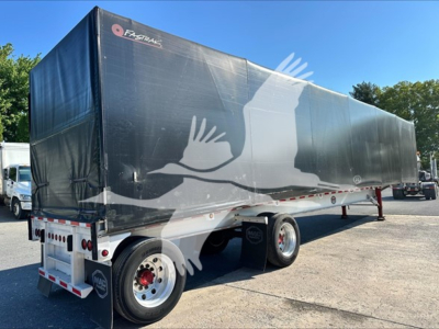 Curtainside trailer showing a black tarp with white crane graphic and red-and-white rear lights.