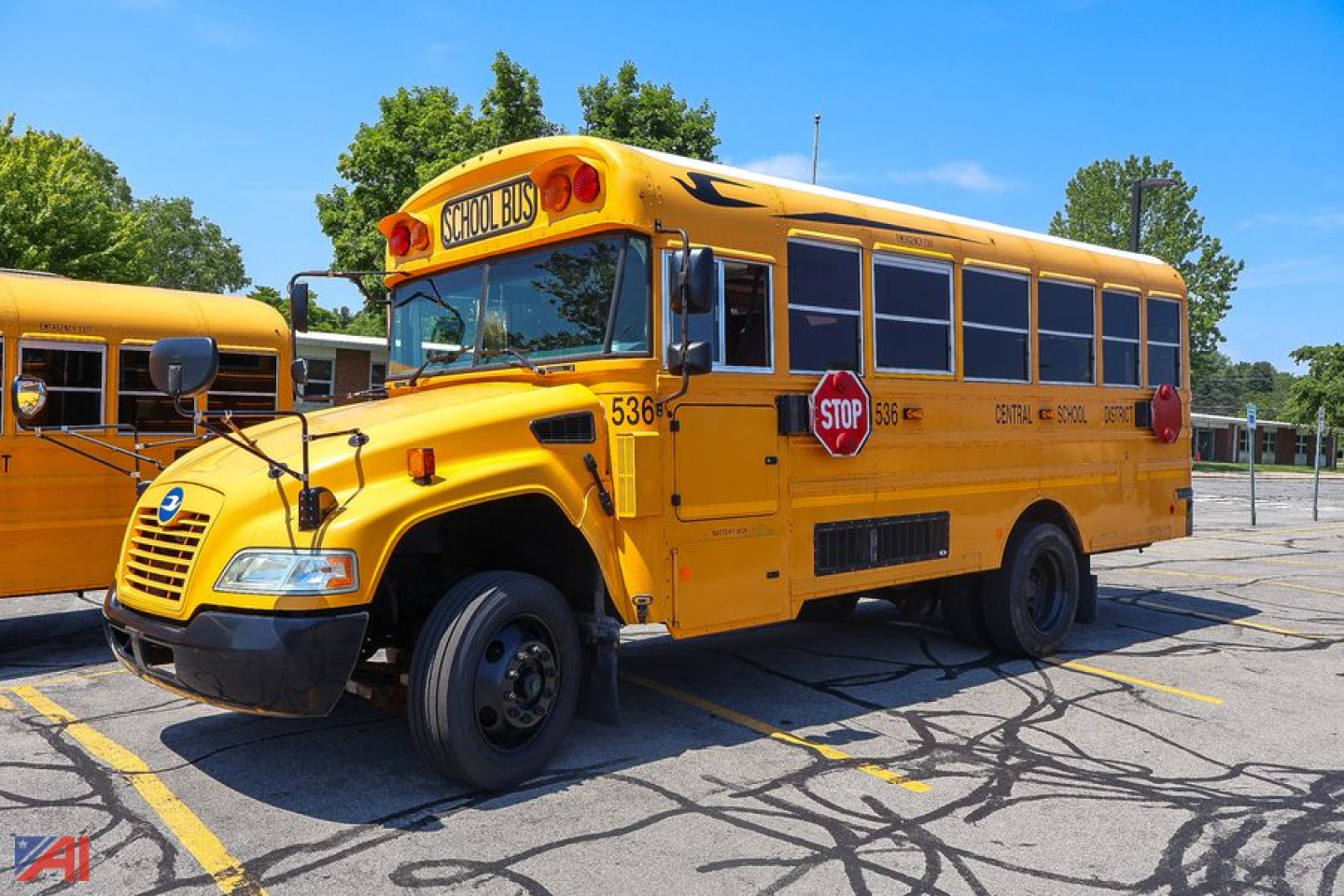 Blue Bird Vision mid-size school bus rear view showing stop sign and school bus lettering.