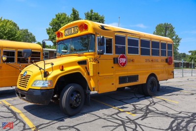 Blue Bird Vision mid-size school bus rear view showing stop sign and school bus lettering.