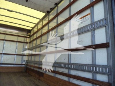 Isuzu NPR HD truck cargo area interior with metal side rails and a white graphic decal of an eagle on the wall.