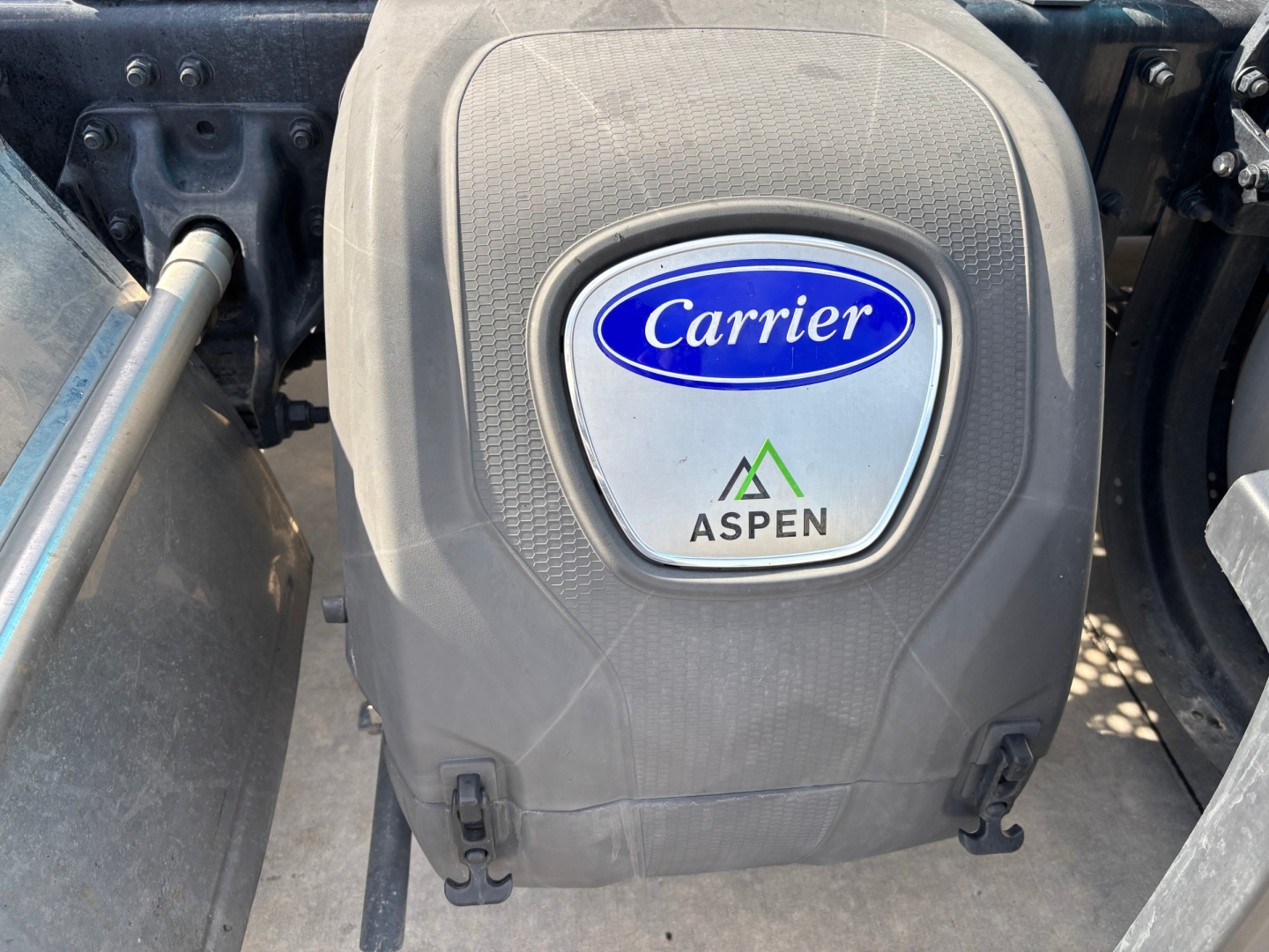 Kenworth T680 engine bay view showing Carrier air compressor cover with Carrier logo and Aspen badge.