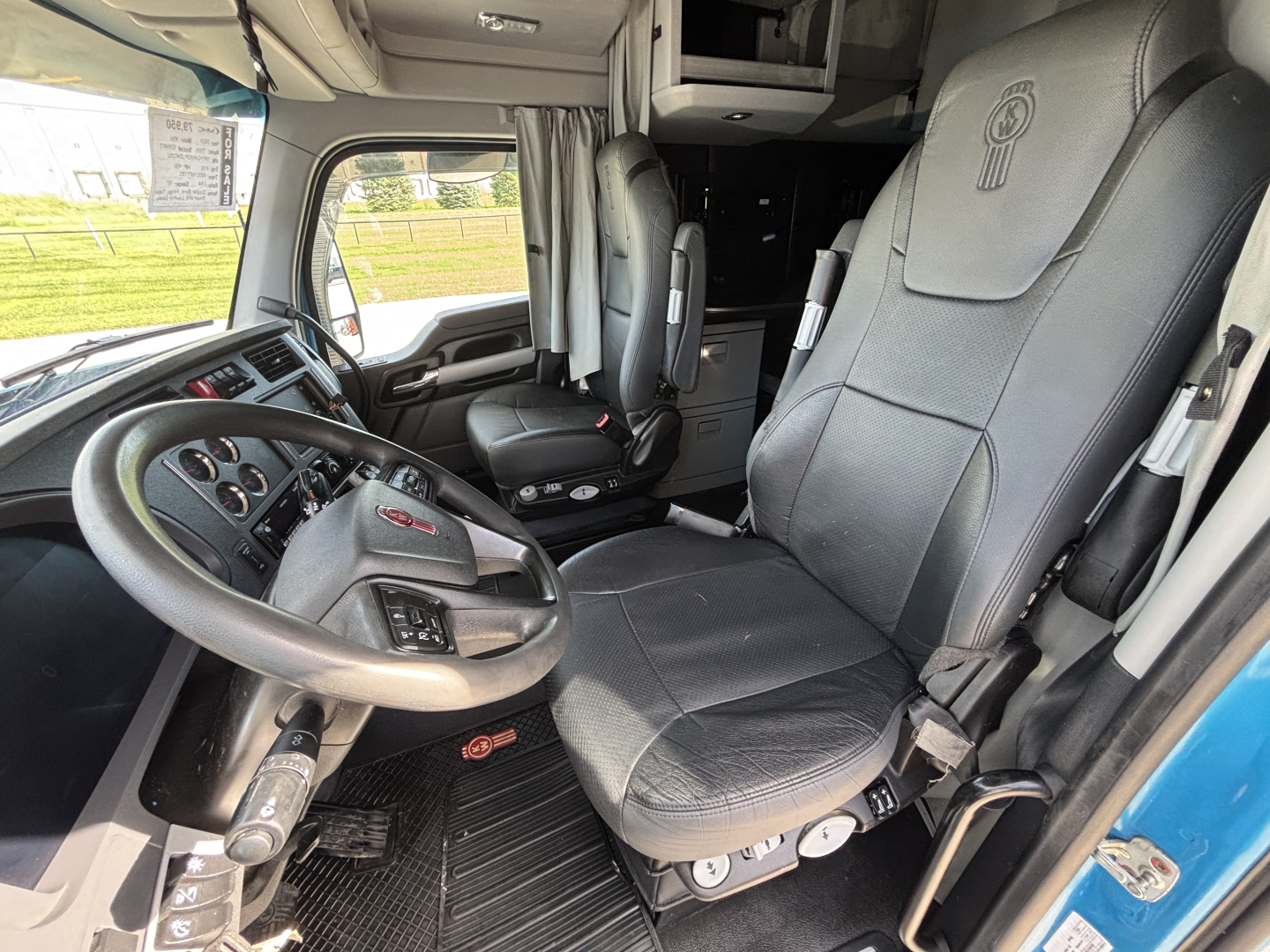 Kenworth T680 truck interior showing driver's seat and dashboard with steering wheel and dashboard controls.