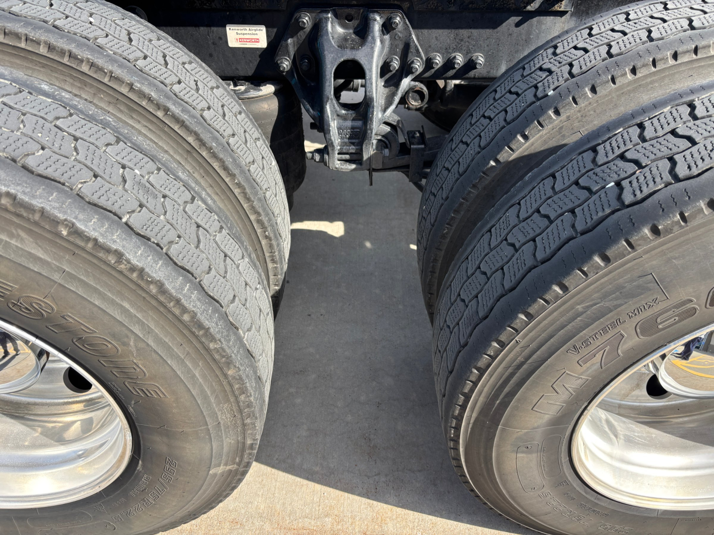 Kenworth T680 tractor rear showing twin rear axles and fifth wheel mounting with tires and rims visible.