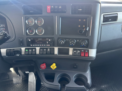 Kenworth T680 dashboard and center console showing gauges, switches, and cup holders.