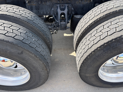 Dual rear wheels on a Kenworth truck chassis showing tire tread and axles.