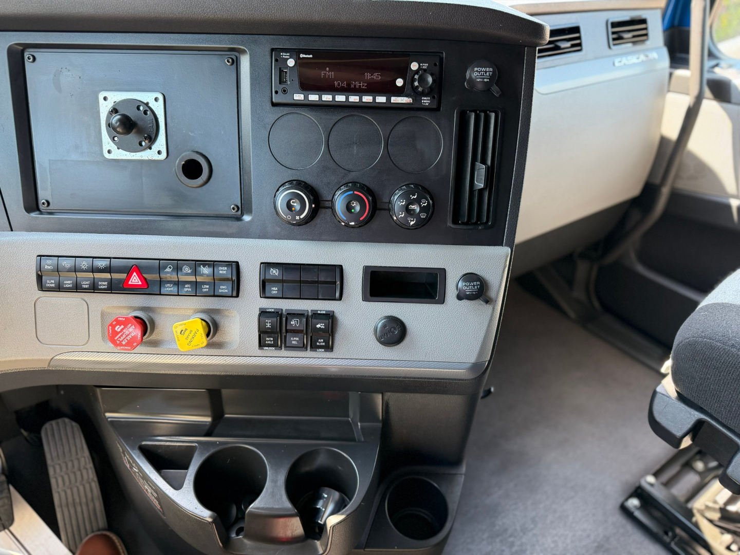 Dashboard of a Freightliner PT126064ST showing instrument panel, control knobs, cup holders, and storage compartments.