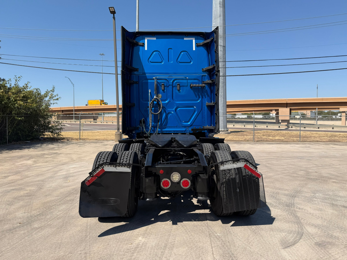 Freightliner PT126064ST rear view showing blue cab, dual rear axles, and fifth-wheel area.