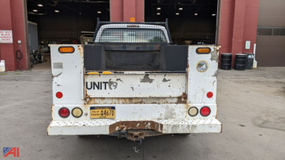 Rear view of a white 2008 Ford F-350 Super Duty utility truck with plow, showing a worn rear bumper, taillights, license plate, and towing hitch.