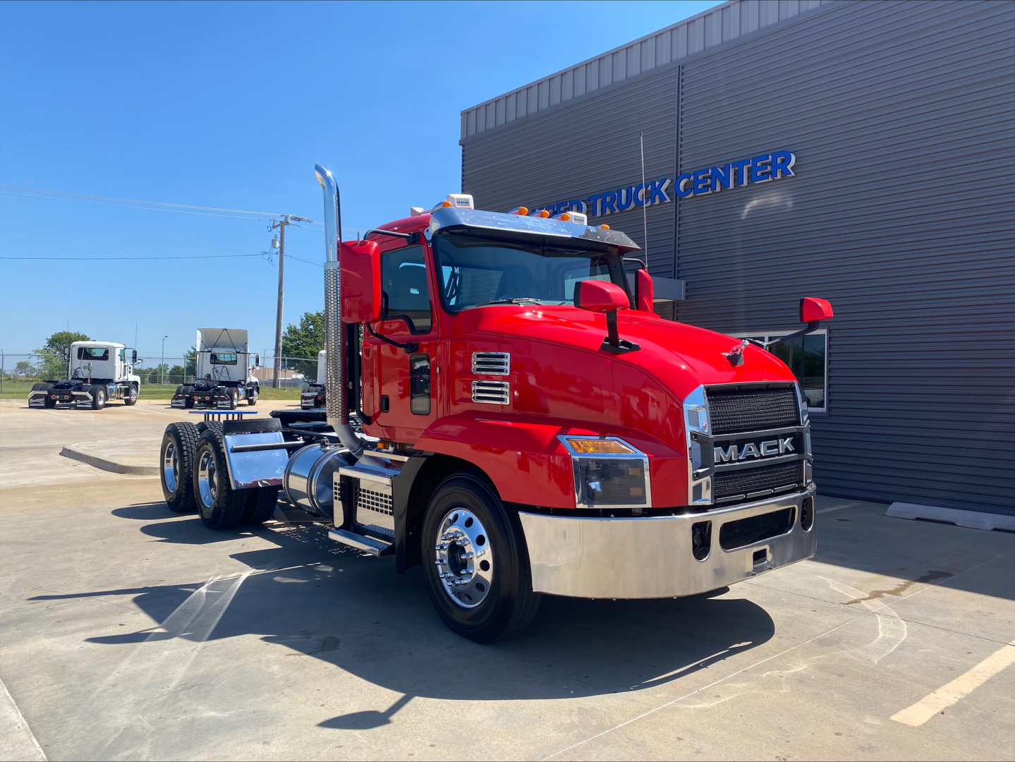 Red 2021 Mack ANTHEM truck in a lot, front-right view showing chrome bumper, dual rear axles, and Mack badge.