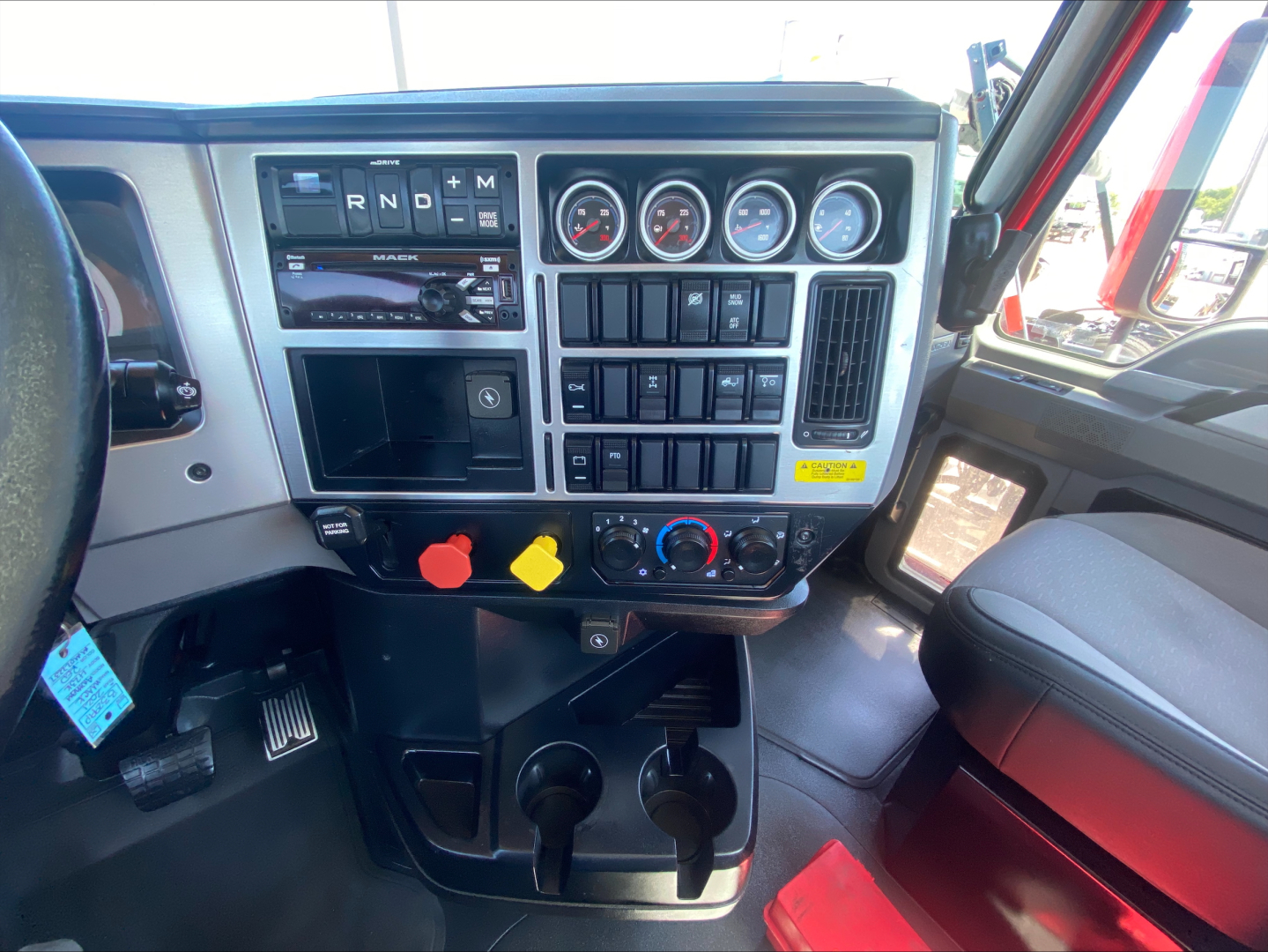 Truck dashboard from a 2021 Mack Anthem showing gauge cluster, controls, and gear selector panel.