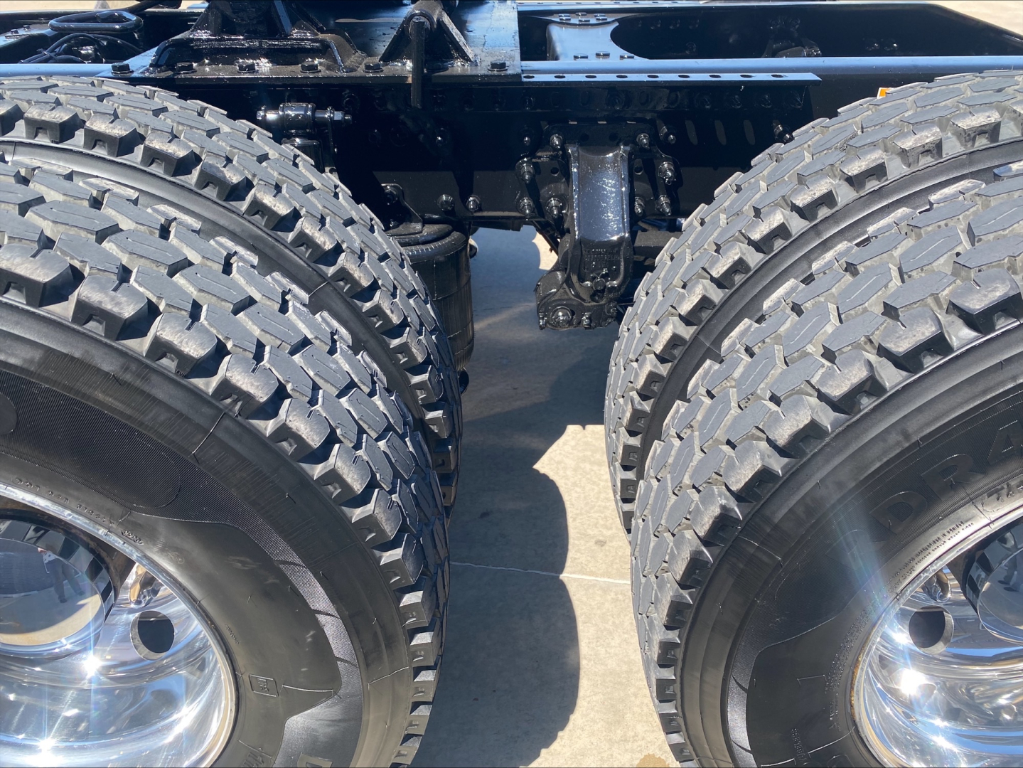 Dual rear drive wheels of a Mack Anthem truck showing dual tires and suspension components.