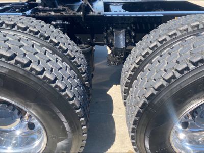 Dual rear drive wheels of a Mack Anthem truck showing dual tires and suspension components.