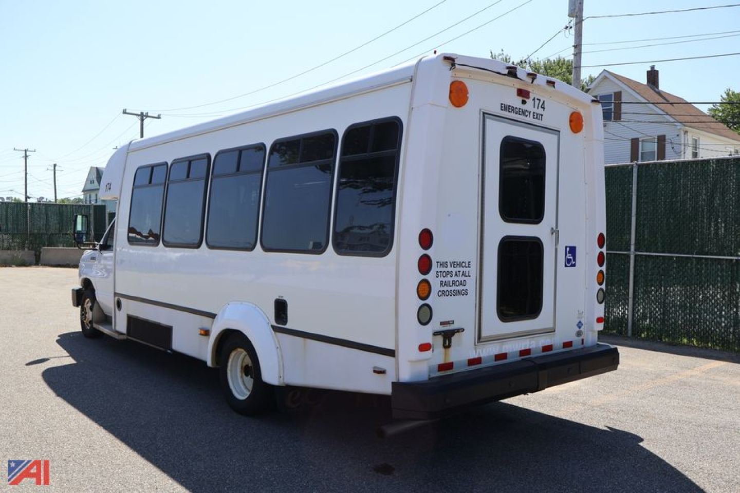 Ford E450 wheelchair bus exterior showing rear and passenger windows, rear door, and accessible placards.