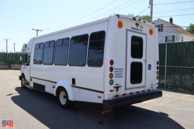 Ford E450 wheelchair bus exterior showing rear and passenger windows, rear door, and accessible placards.