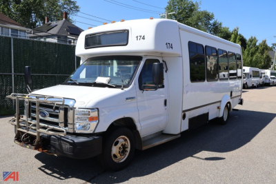 Ford E-450 shuttle bus with wheelchair lift, white body, front grille guard, number 174 on top corners, side windows, near-new condition road side view.