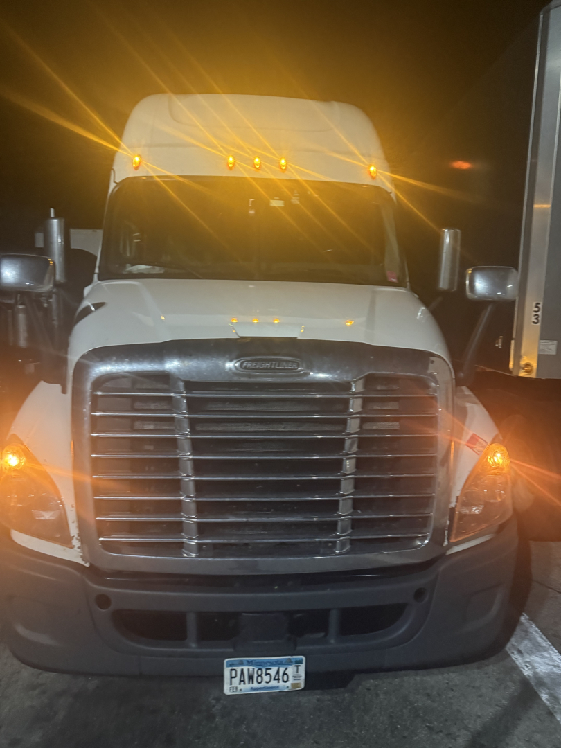 Front view of a white Freightliner truck showing grille, headlights, and front bumper. License plate visible PAN8546.