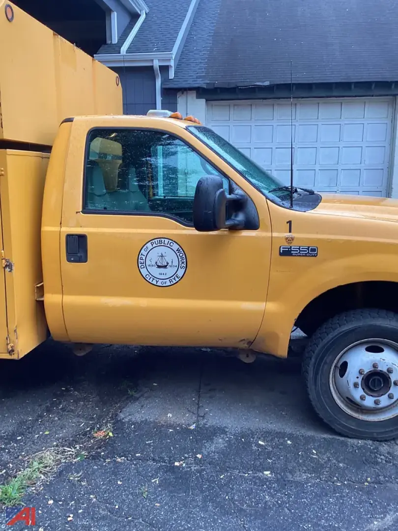 Ford F-550 Super Duty utility dump truck side view showing cab door with city seal and F-550 badge.