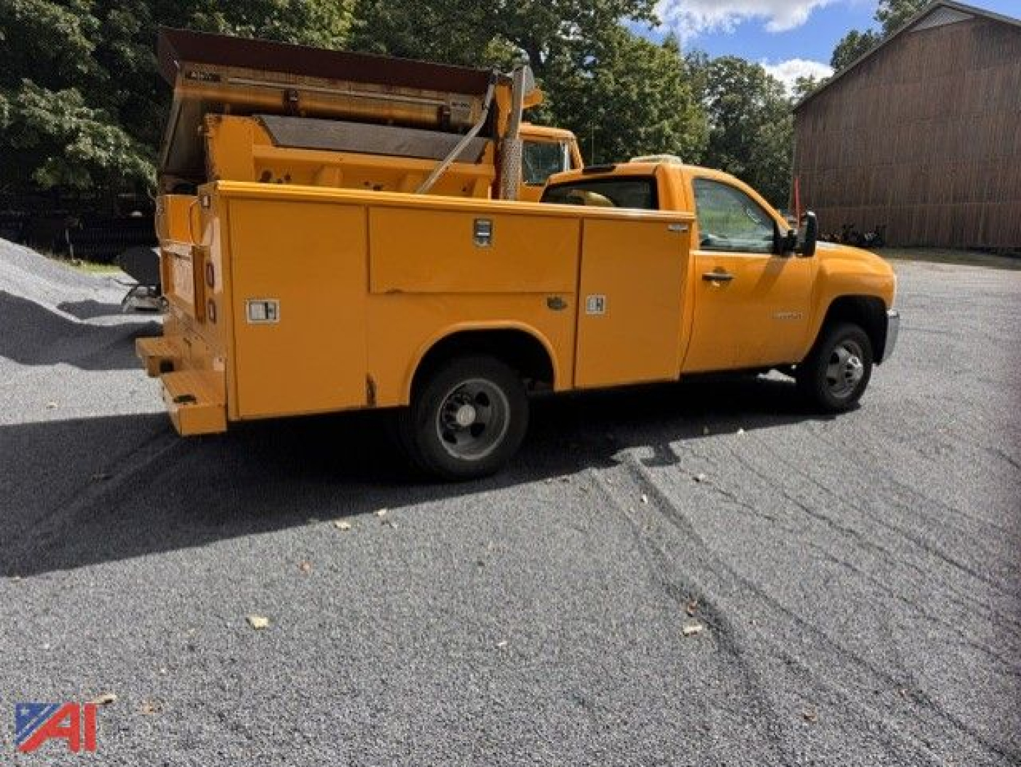 Chevrolet Silverado 3500HD utility service truck in yellow with utility bed and equipment compartments, side view.