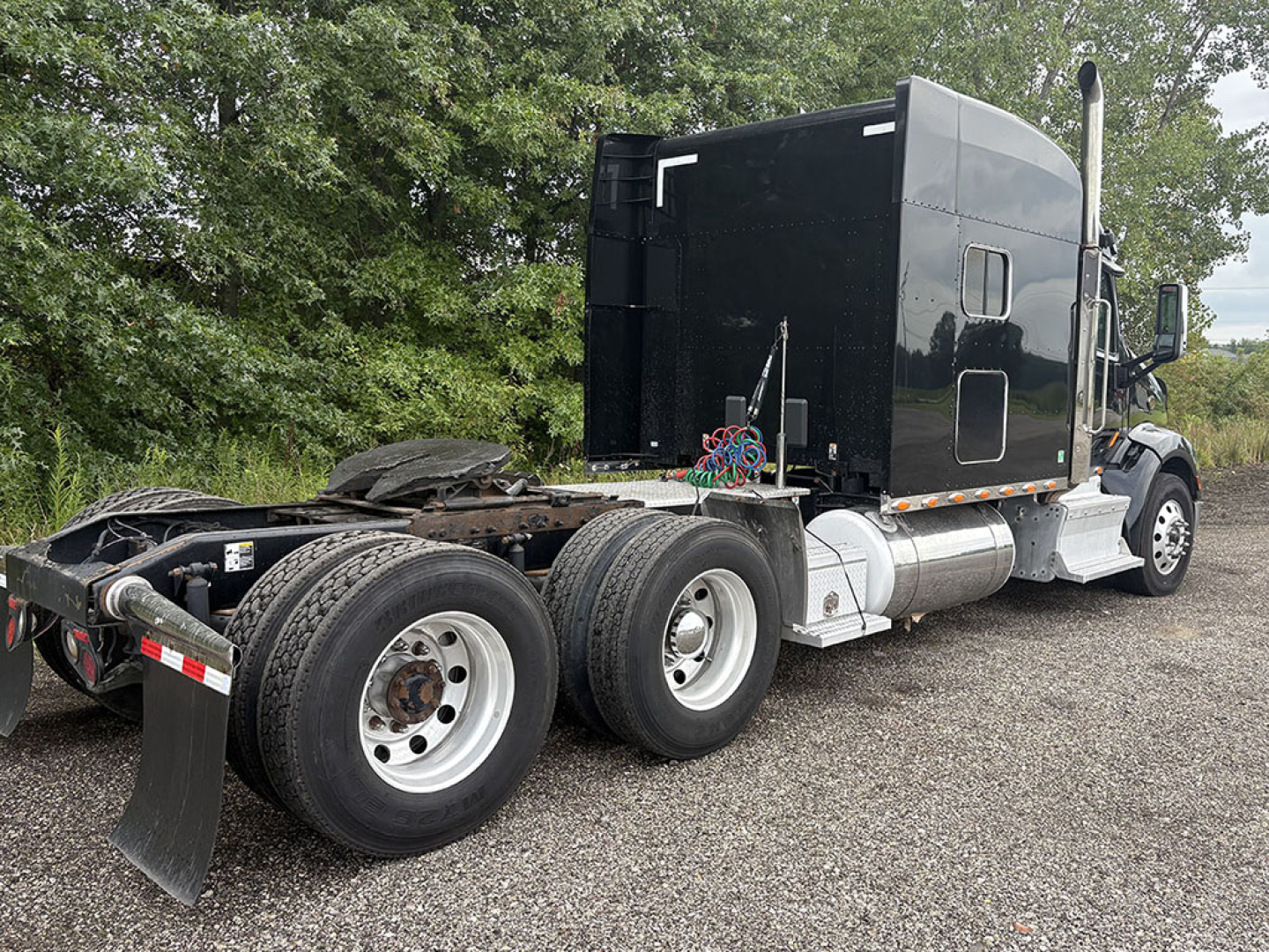 Peterbilt 579 UltraCab tractor chassis showing rear dual axles with fifth wheel and exhaust stack.