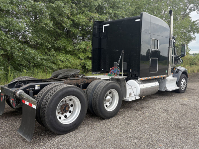 Peterbilt 579 UltraCab tractor chassis showing rear dual axles with fifth wheel and exhaust stack.
