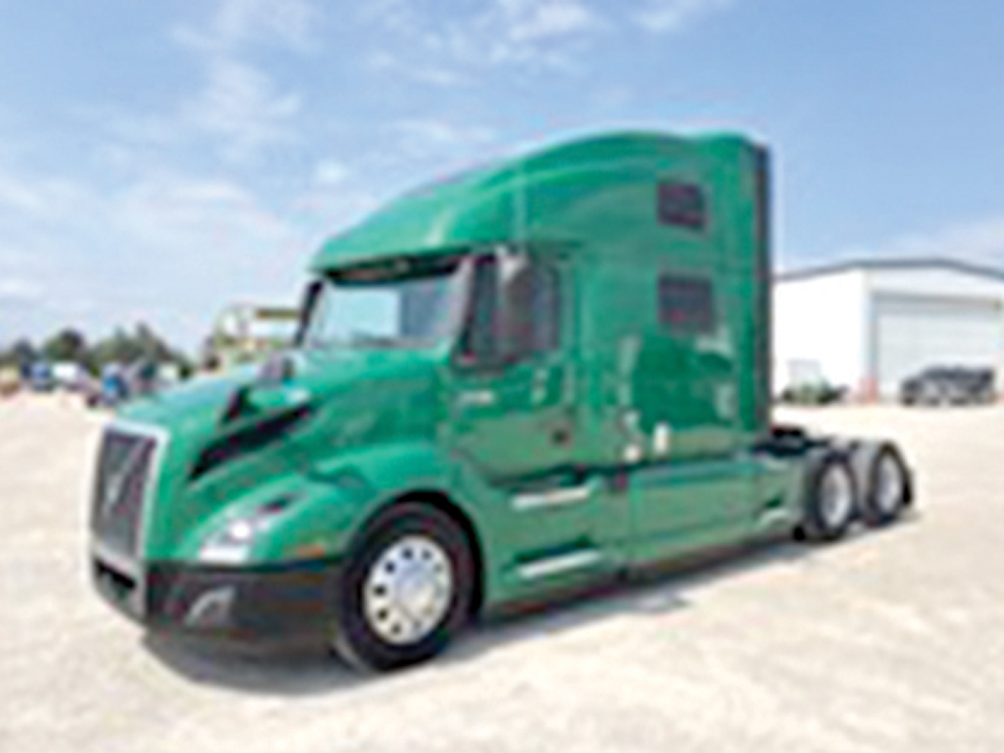 Green Volvo VNL 860 semi truck in a lot, cab and sleeper visible with wheels and visor, no legible badges or text.