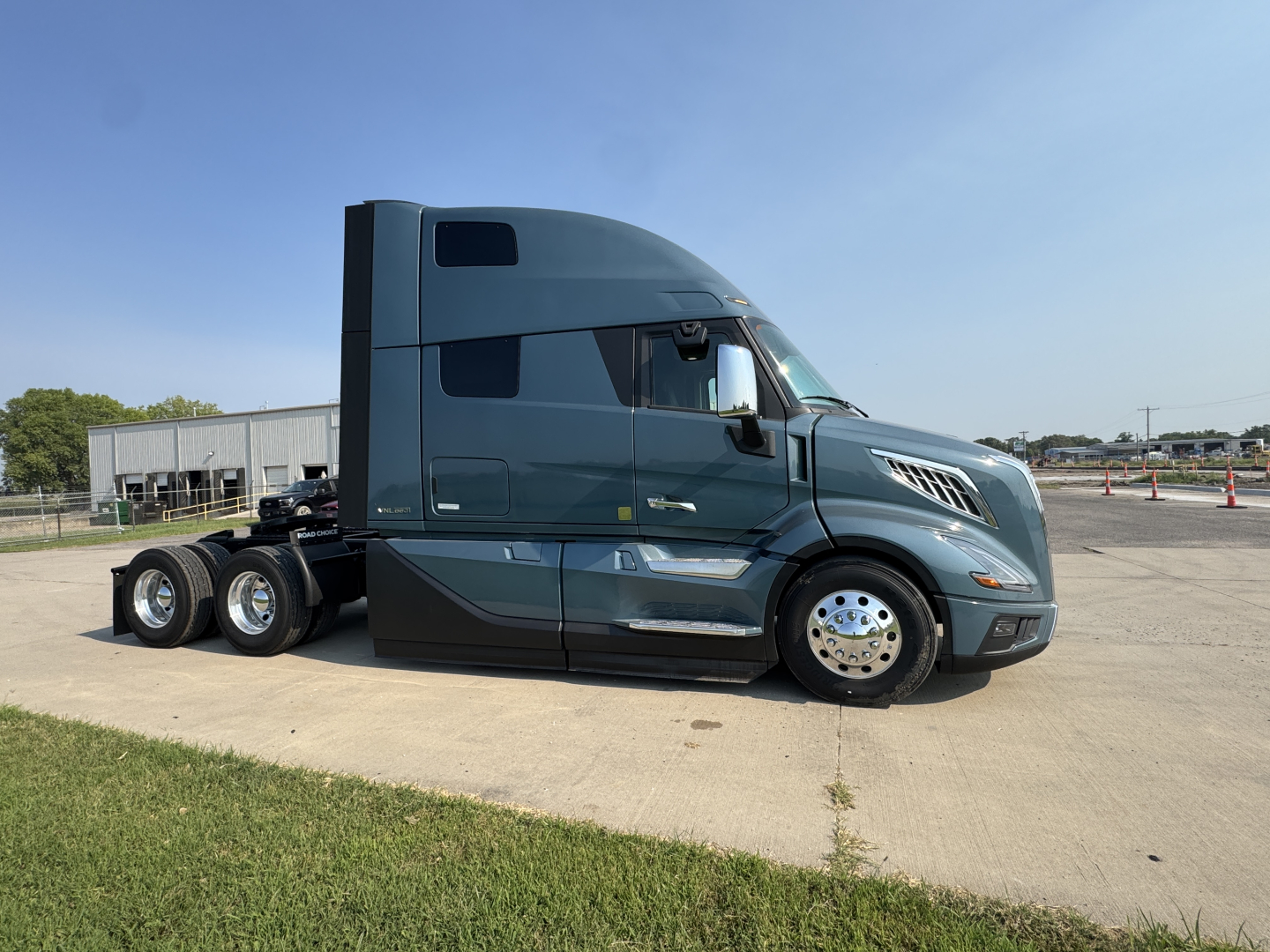 Truck tractor side profile showing Volvo VNL64T860 sleeper cab with dual rear axles and chrome wheels.