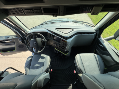 Volvo VNL64T860 cabin interior showing steering wheel, dashboard, and two front seats.
