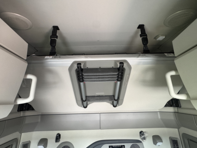 Volvo VNL64T860 sleeper cab interior showing overhead bunk ladder/storage and light fixtures.