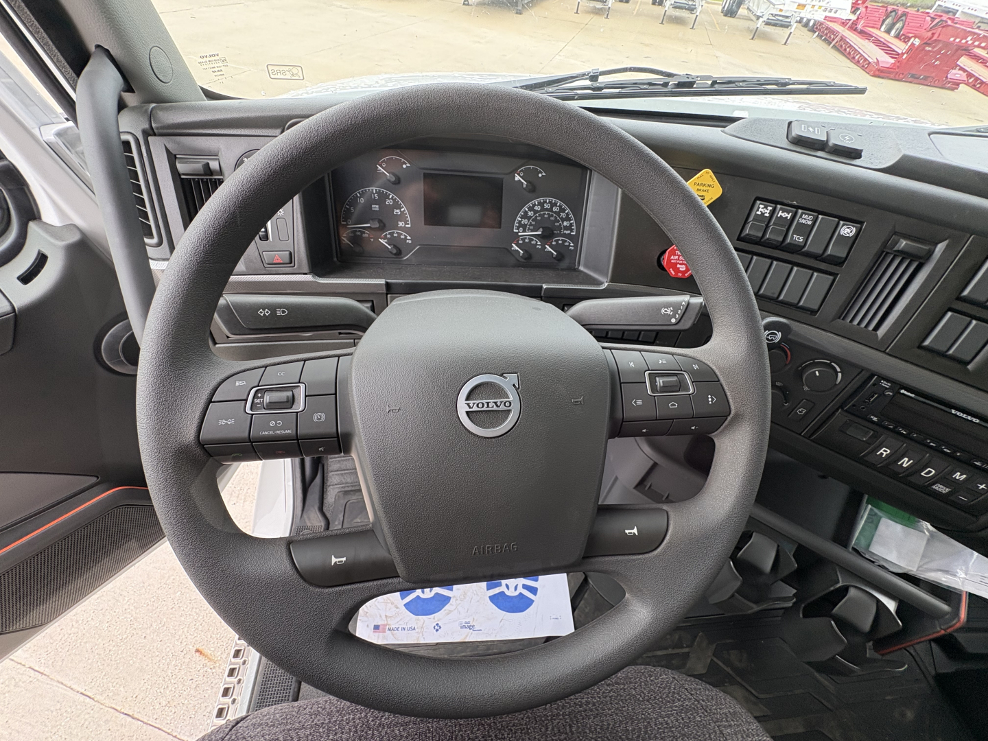 Volvo VHD84F300 truck interior steering wheel and dashboard with instrument cluster and control buttons.