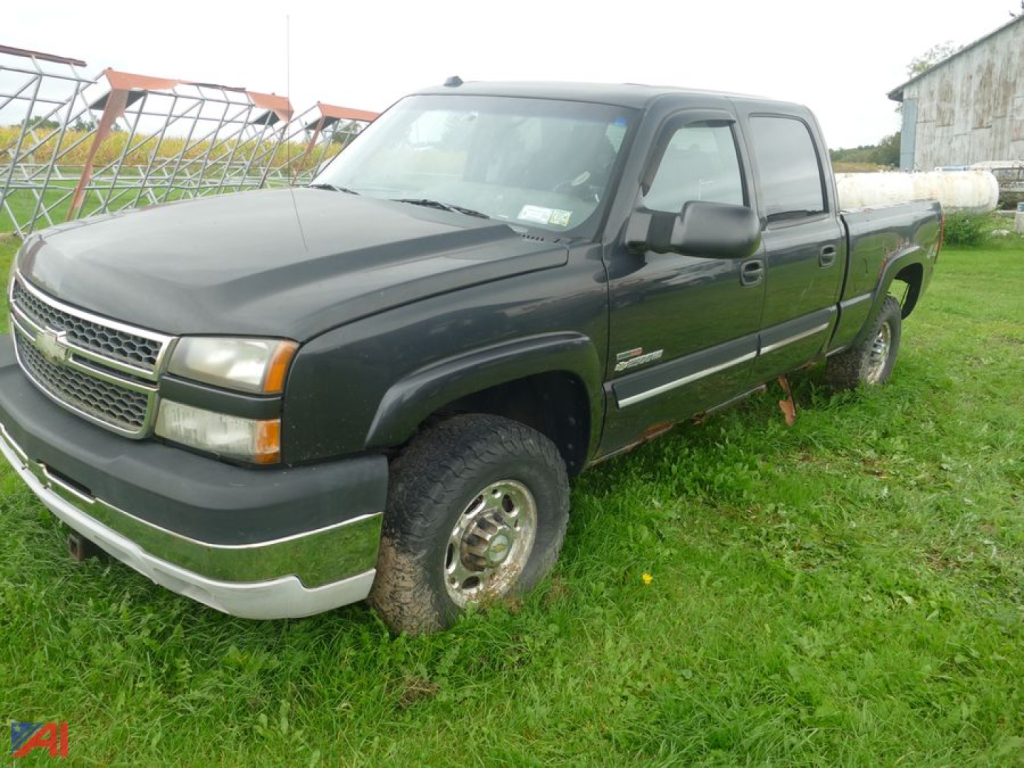 Chevrolet Silverado 2500 pickup truck in a grassy lot, black exterior, extended cab, four-wheel drive, front chrome bumper.