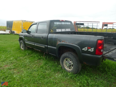 Chevrolet Silverado 2500 pickup truck with 4x4 badge, side view, diesel decal on rear window, in a grassy lot.