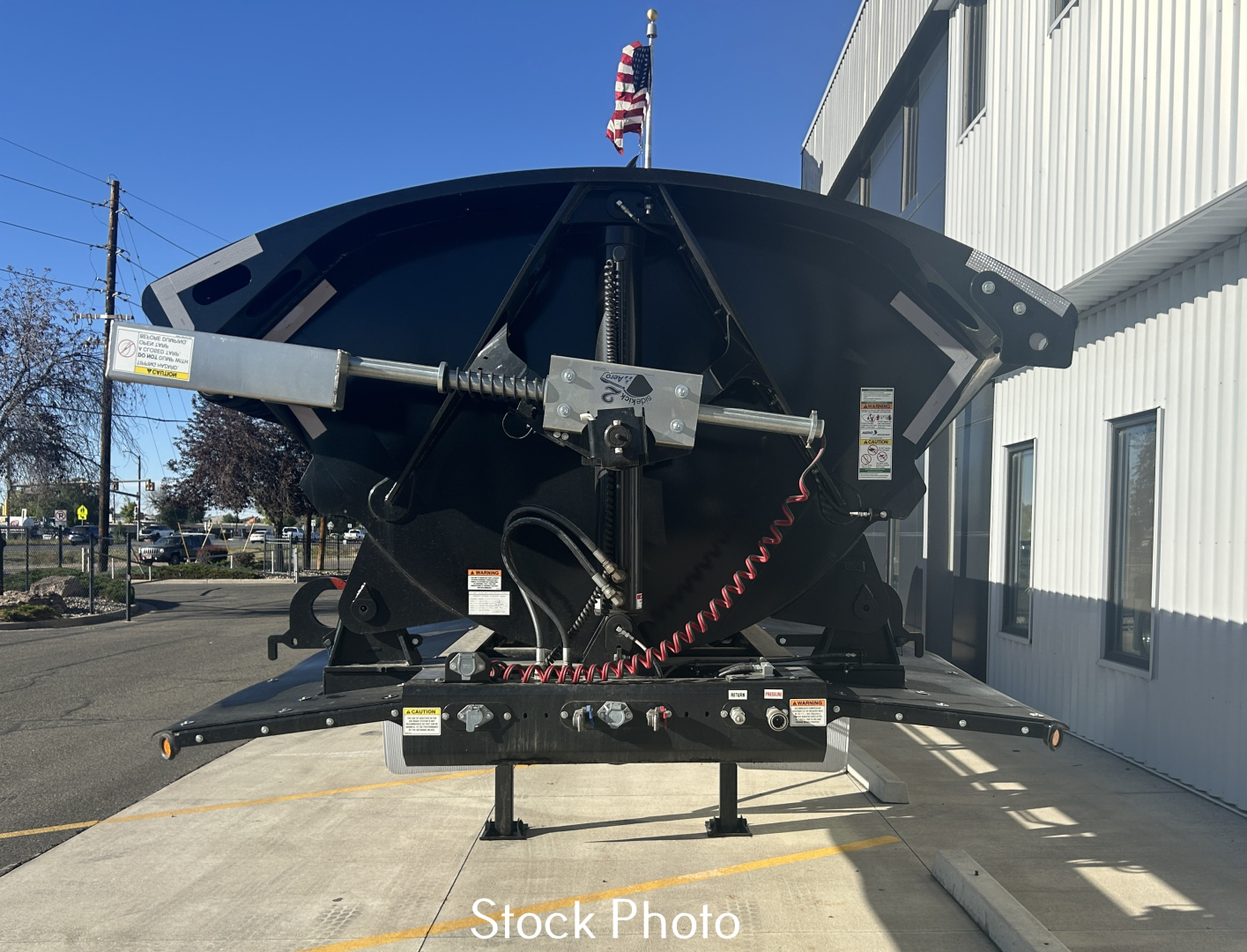 Dump trailer hitch mechanism and bed with hydraulic components and wiring visible in stock photo.