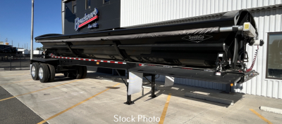 Trailer in stock showing SmithCo SX2-4034 dump trailer with dual axles, black hydraulic hopper, and landing gear in view.