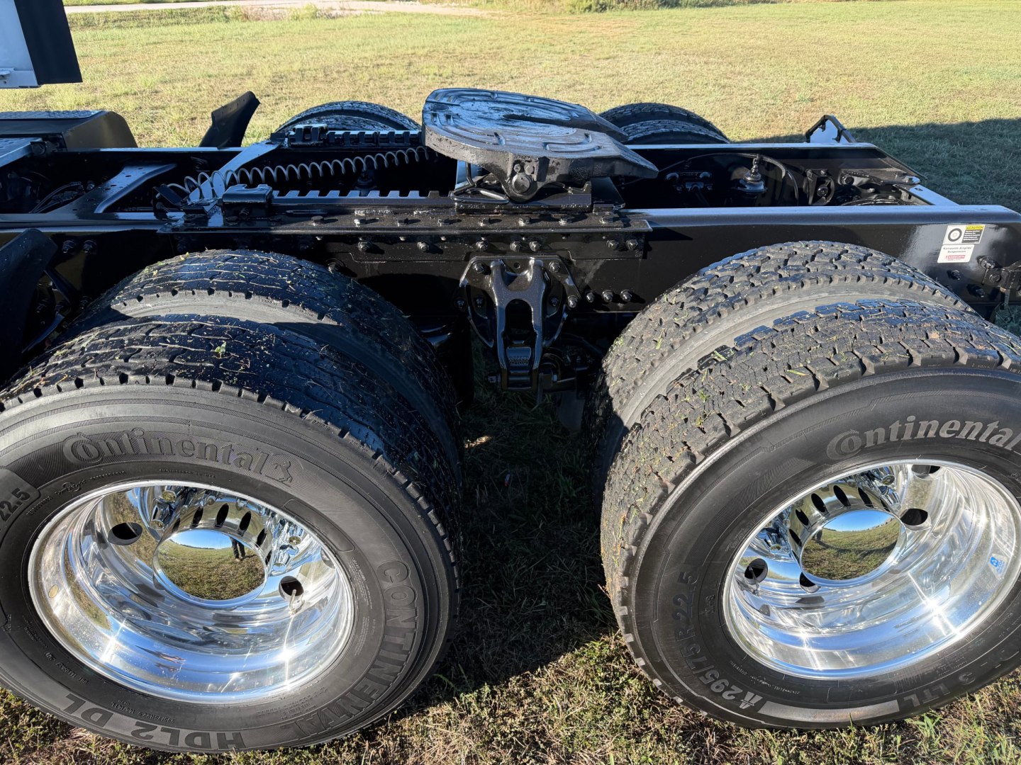 Kenworth truck rear dual wheels with chrome rims and Continental tires mounted on a fifth wheel chassis showing tire treads and wheel hubs.