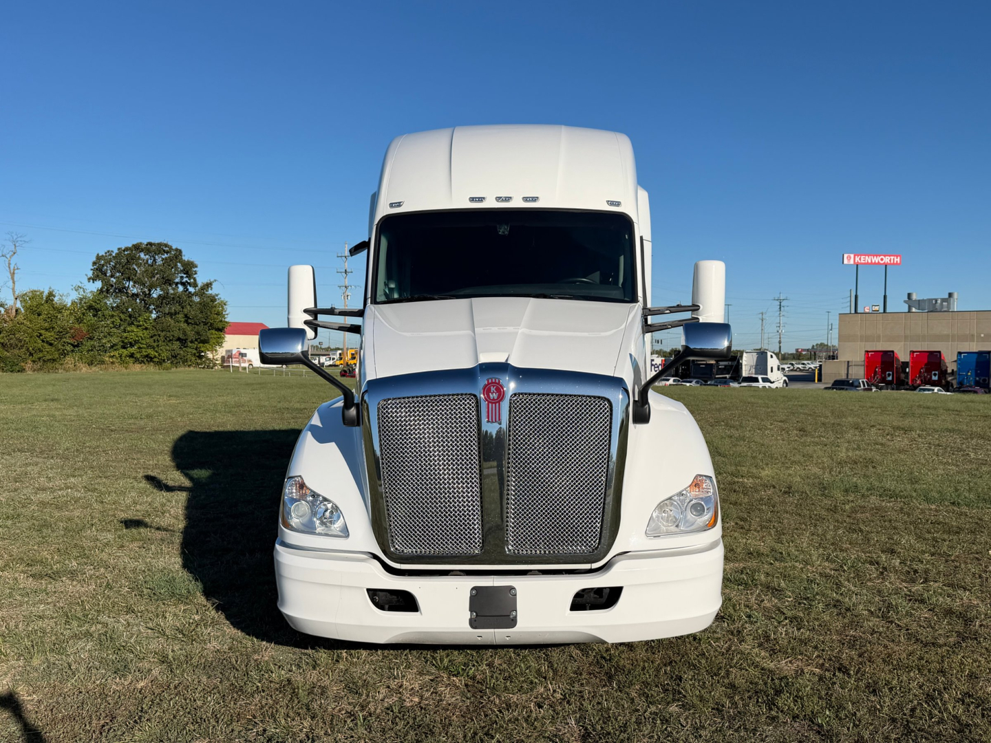 Kenworth T680 front view showing large chrome grille and dual hood vents in a white truck