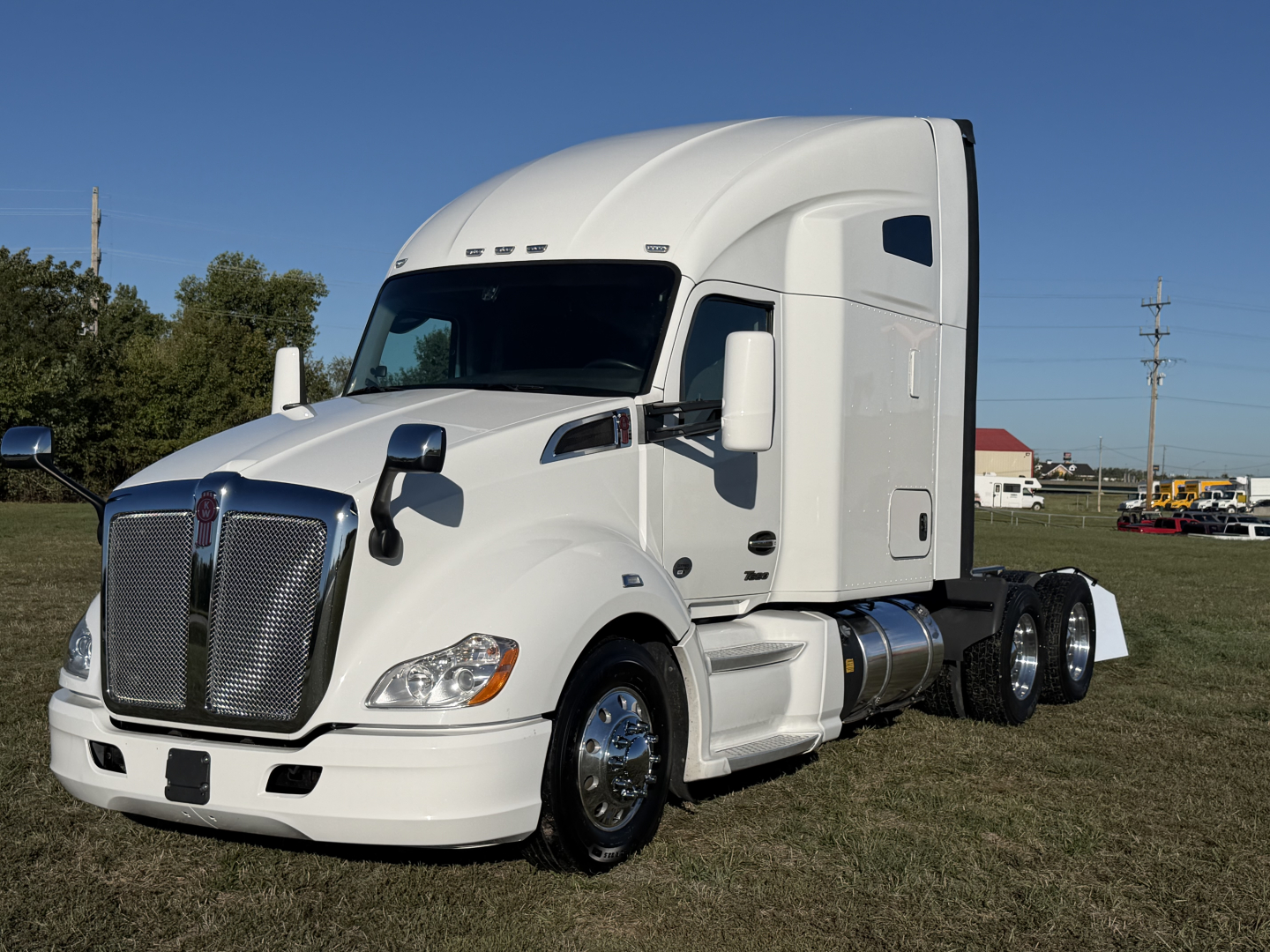 Kenworth T680 long-hood sleeper tractor in white, side view showing cab, front grille, and fuel tanks.