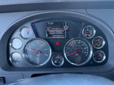 Kenworth T680 dashboard cluster with speedometer, tachometer, and digital display showing system message and gauges