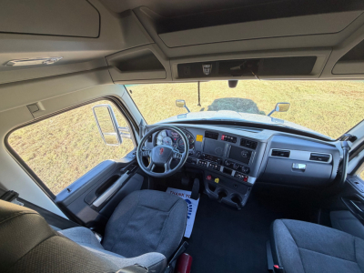 Dashboard and interior of a 2022 Kenworth T680 from the driver’s seat, showing steering wheel, instrument cluster, center console, and seating.