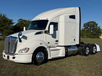 Kenworth T680 tractor in profile view, white sleeper cab, dual rear axles, chrome wheels, no visible text from this angle