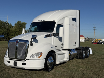 Kenworth T680 long-hood sleeper tractor in white, side view showing cab, front grille, and fuel tanks.