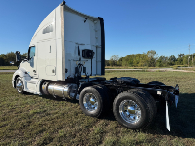 Kenworth T680 truck side view with sleeper cab, dual rear axles, chrome wheels. Visible text includes no legible labels on tanks or panels from distance.