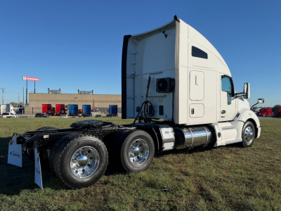 Kenworth T680 truck tractor side view showing sleeper cab and tandem rear axles.